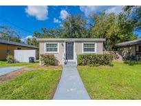 Tan house with gray walkway, landscaping, and a fenced yard at 1506 W 16Th St, Sanford, FL 32771