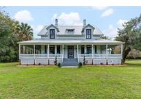 Charming two-story home with wrap-around porch and expansive lawn at 511 E Mirror Lake Dr, Fruitland Park, FL 34731