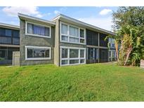 Exterior view of condo building with green lawn at 5783 Peregrine Ave # C07, Orlando, FL 32819