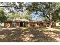 Ranch style brick home with mature oak trees and a spacious yard at 7129 Oakwind Dr, Orlando, FL 32818