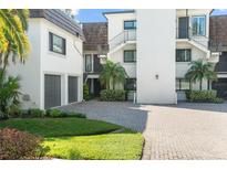 Exterior view of condo building with attached garage and paved driveway at 8984 Houston Pl # 103, Orlando, FL 32819