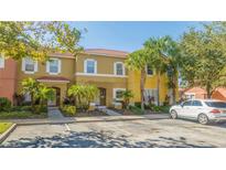 Townhome exterior; two-story, light yellow with lush landscaping at 8581 Bay Lilly Loop, Kissimmee, FL 34747