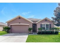 A charming one-story house with a two-car garage and a well-maintained lawn at 2036 Van Buren Loop, Auburndale, FL 33823