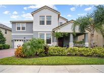 Two-story home with gray siding, landscaping, and a two-car garage at 9747 Lost Creek Dr, Winter Garden, FL 34787