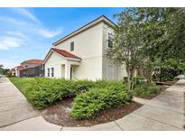 Two-story house with light-colored exterior, landscaping, and sidewalk at 4562 Baleno Ln, Kissimmee, FL 34746