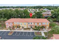 Aerial view of townhouses with parking and landscaping at 1029 Park Ridge Cir, Kissimmee, FL 34746