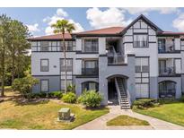 Two-story building exterior with gray and white accents, stairs, and landscaping at 3702 Palm Desert Ln # 5431, Orlando, FL 32839