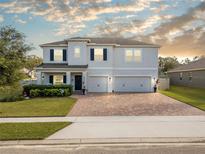 Two-story home with a three-car garage and landscaped lawn at 1511 Orange Valley Rdg, Ocoee, FL 34761