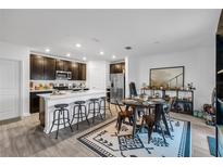 Modern kitchen with island, stainless steel appliances, and dark cabinets at 1093 Berry Ln, Davenport, FL 33837