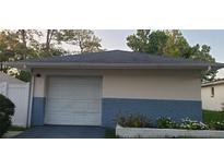 Detached garage with white door, light beige walls, and blue brick base at 4721 Watch Hill Ct, Orlando, FL 32808