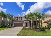 Two-story house with garage and palm trees at 5295 Wildwood Way, Davenport, FL 33837