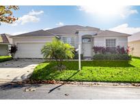 Single-story home with attached garage and well-manicured lawn at 344 Grosvenor Loop, Davenport, FL 33897