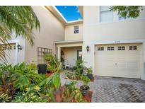 Townhouse with landscaped front yard and paver driveway at 2102 Cypress Bay Blvd, Kissimmee, FL 34743