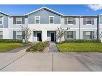 Two-story light blue townhome with gray trim at 627 Jasmine Ln, Davenport, FL 33897