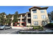 Exterior view of a residential building with parking and landscaping at 914 Charo Pkwy # 114, Davenport, FL 33897