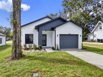 Modern two-toned house with a gray garage door and well-manicured lawn at 508 Roger Williams Rd, Apopka, FL 32703