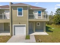 Two-story townhome with attached garage and balcony at 450 Lake Shore Pkwy, Davenport, FL 33896