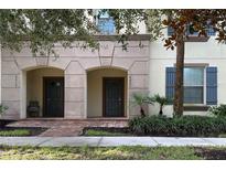 Townhouse exterior with two entrances, brick walkway, and lush landscaping at 9033 Rhodes St, Kissimmee, FL 34747