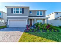 Two story house with gray siding, landscaping, and a double garage at 4009 Winding Meadows St, Apopka, FL 32712