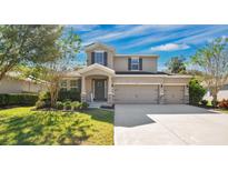 Two-story house with a three-car garage and nicely landscaped yard at 521 Morgan Wood Dr, Deland, FL 32724