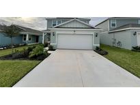 Two-story house with green exterior, two-car garage, and landscaped lawn at 2227 Lovely Ln, Davenport, FL 33896