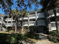 Exterior view of an apartment building with balconies and lush landscaping at 14013 Fairway Island Dr # 415, Orlando, FL 32837