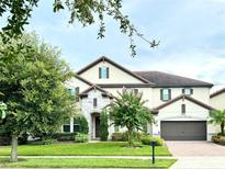 Two-story house with stone accents and a three-car garage at 8426 Morehouse Dr, Orlando, FL 32836