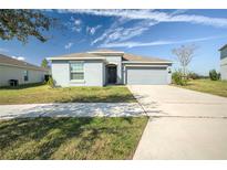 One-story home with gray exterior, attached garage, and manicured lawn at 168 Taft Dr, Davenport, FL 33837