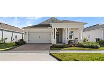 Single-story house with light-colored exterior, covered porch, and landscaping at 2071 Limestone Trl, Kissimmee, FL 34747