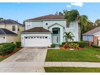 Two-story house with light teal exterior, white garage door, and landscaped lawn at 1055 Lake Berkley Dr, Kissimmee, FL 34746