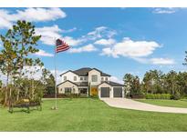 Two-story house with a three-car garage, and landscaping at 4001 Ainsley Ave, Orlando, FL 32833