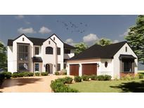 Two-story home with white brick, black roof, and three-car garage at 17710 Broad St, Montverde, FL 34756