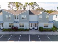 Modern townhome with gray siding, stone accents, and two-car parking at 7960 Formosa Valley Pl, Kissimmee, FL 34747