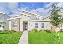 Modern two-story home with stone accents and landscaped lawn at 730 Drop Shot Dr, Davenport, FL 33896