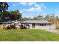 Updated one-story home with gray siding, metal roof, and landscaped lawn at 1190 Perch Dr, Saint Cloud, FL 34771