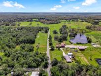 Aerial view of a rural property with a pond and surrounding trees at 350 S 5Th St, Orlando, FL 32833