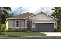 One-story home with gray siding, stone accents, and a two-car garage at 399 Eventide Ave, Mascotte, FL 34753