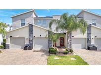 Modern three-unit townhome building with attached garages at 543 Ocean Course Ave, Davenport, FL 33896