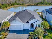 Single-story home with a lake view and a three-car garage at 668 Mosaic Blvd, Daytona Beach, FL 32124