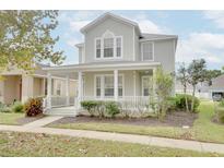 Two story home with front porch and landscaping at 7041 Buttonbush Loop, Harmony, FL 34773