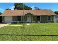 Front view of a charming ranch-style home with a single-car garage and well-maintained lawn at 110 Angeles Rd, Debary, FL 32713