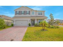 Two story house with brick paver driveway and landscaping at 5045 Rain Shadow Dr, St Cloud, FL 34772