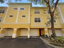 Three-story building with yellow exterior and attached garages at 1711 Shadow View Cir # 1711, Maitland, FL 32751