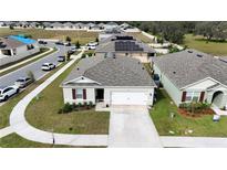 Aerial view of a house with gray roof and a two-car garage, surrounded by other houses at 564 Boardwalk Ave, Haines City, FL 33844