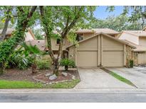 Two-story townhome with a double garage and lush landscaping at 358 Winchester Ct, Longwood, FL 32779