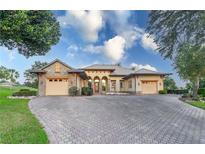 House exterior features stone accents, a three-car garage, and a paved driveway at 38748 Lakeview Walk, Lady Lake, FL 32159