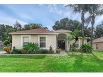 One-story house with a light-colored facade, brown roof, and lush landscaping at 217 Winding Cove Ave, Apopka, FL 32703