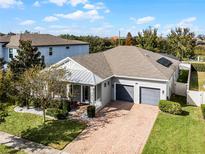 Front view of a gray house with a metal roof and two-car garage at 16653 Toccoa Row, Winter Garden, FL 34787