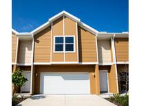 Exterior of tan two-story home with a white garage door at 107 Oceans Cir, Daytona Beach Shores, FL 32118