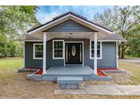 Gray house with a white trim and black front door at 31444 Orange St, Sorrento, FL 32776